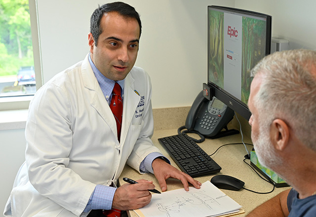 Doctor sitting at his desk speaking with a patient