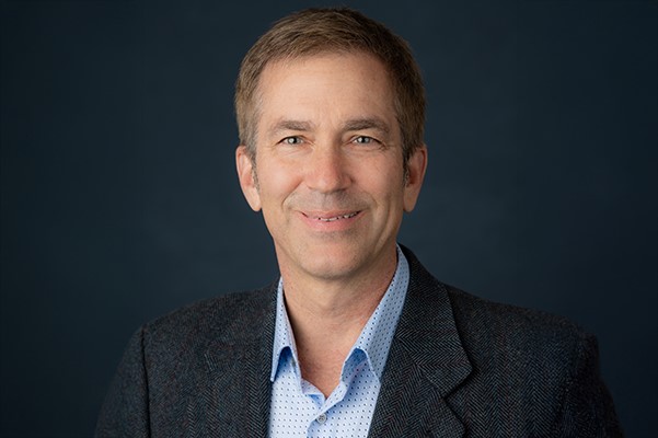 male doctor with a blue shirt and black jacket
