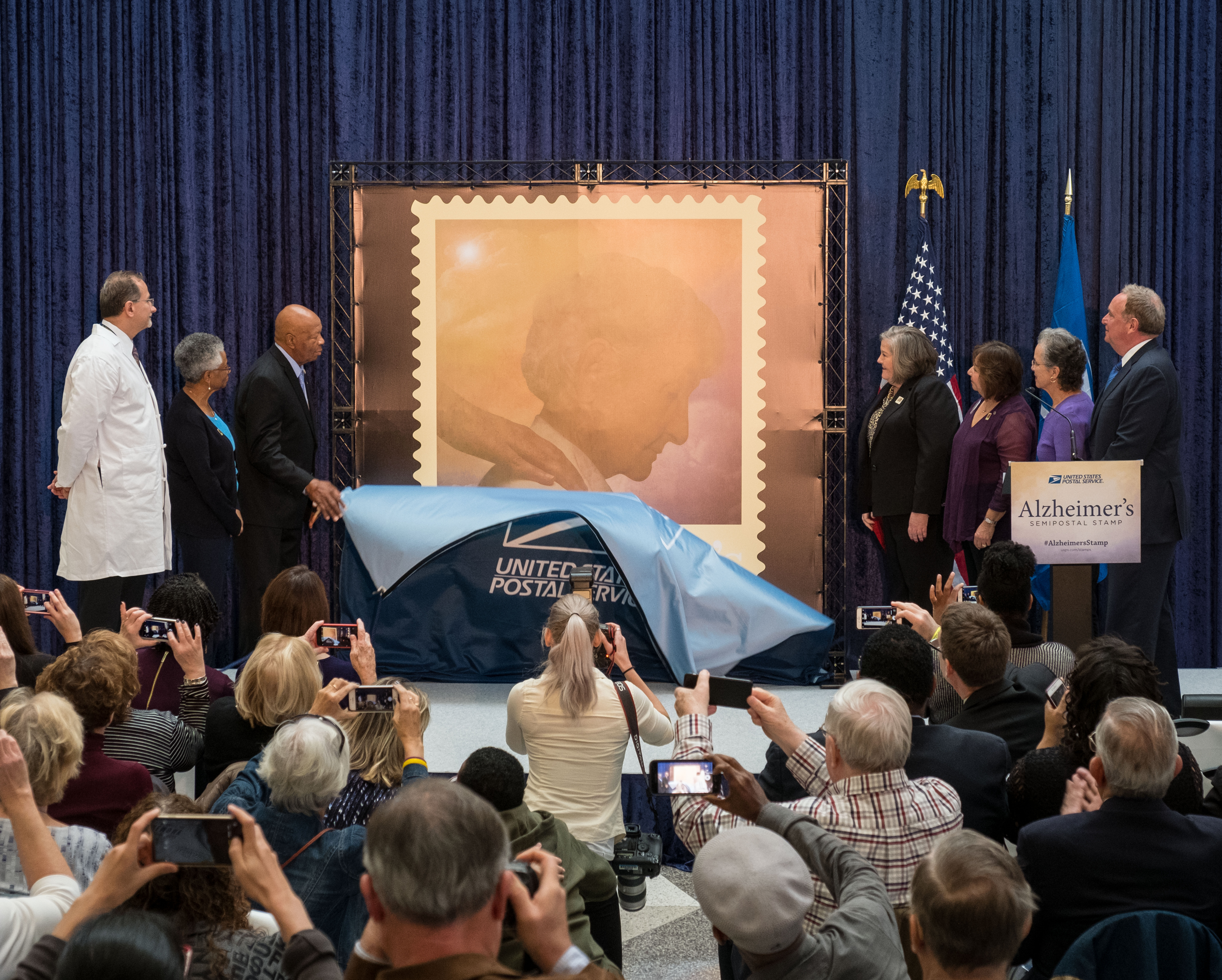 A photo shows the unveiling of the stamp for Alzheimer's disease. 