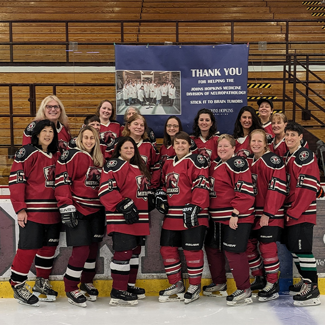 A team of female hockey players stand together.