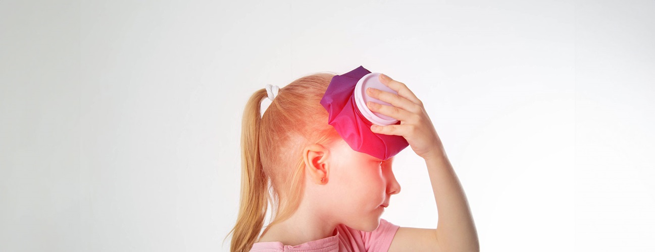 child holds an icepack to her head
