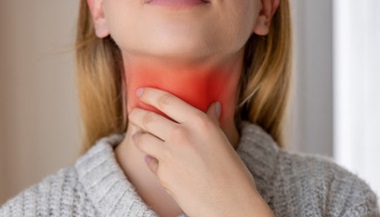 Woman holding her throat in pain