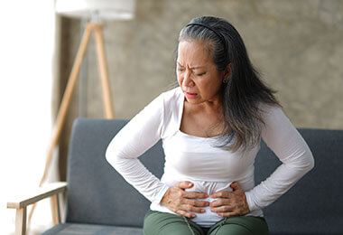 a woman with collagenous and lymphocytic colitis holds her stomach