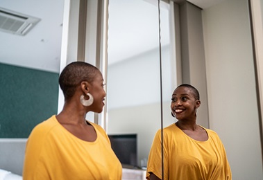 A woman looking happily into the mirror