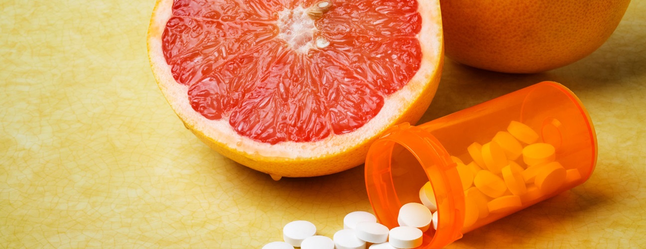 Sliced grapefruit sitting next to prescription medicine