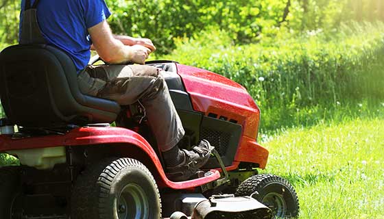 A man rides a lawnmower.