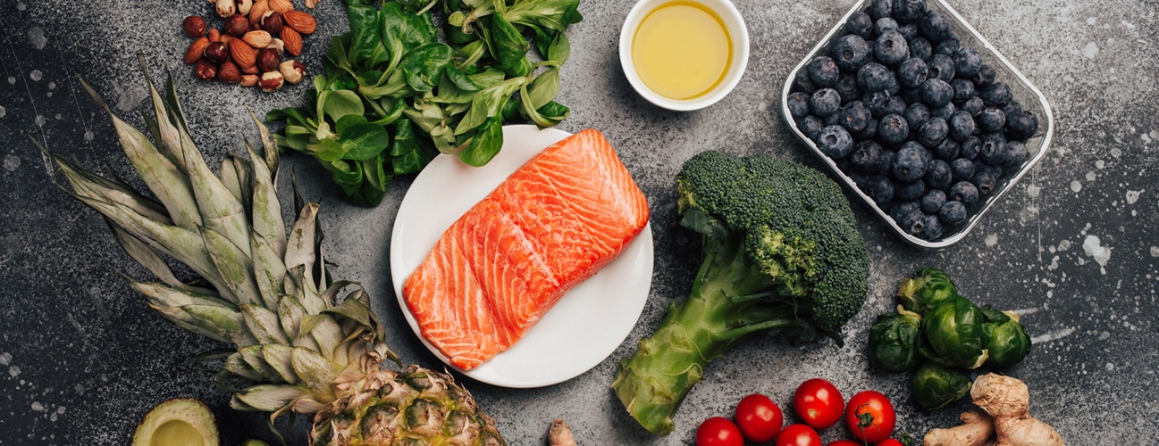A selection of inflammation-safe foods, including salmon, pineapple, broccoli, blueberry and other fruits and vegetables