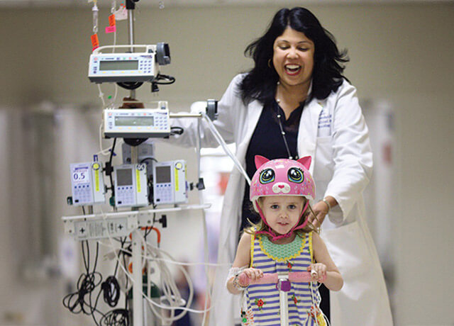 Dr. Kudchadkar running with a child down the hallway