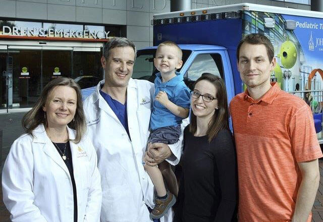 family and doctors outside an ambulance