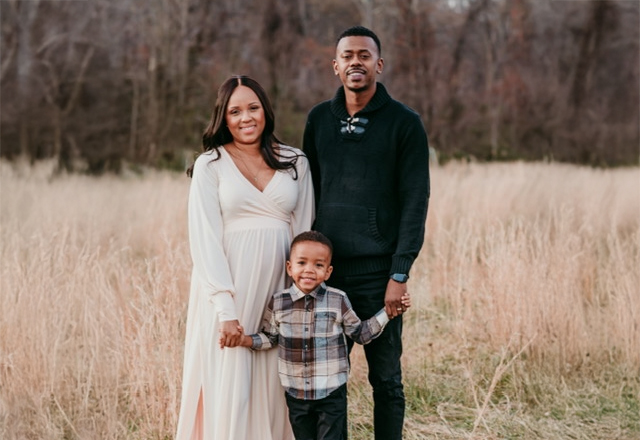 Pregnant Amanda, her husband and son in a field.