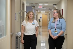 Three women around a laptop learning about the residency program at Johns Hopkins All Children's Hospital.