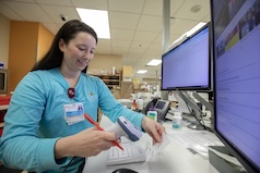 Woman examining a prescription bottle to provide dosage instructions.