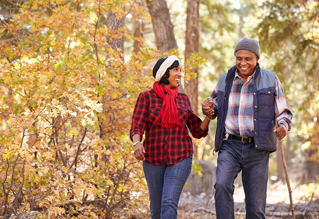a mature couple hikes together in the fall
