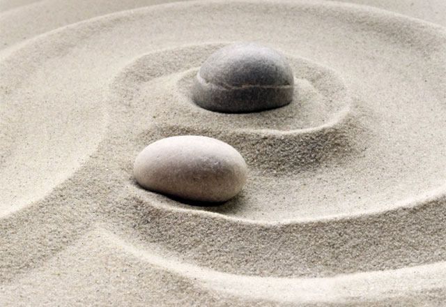 Stones sitting in a sand garden.