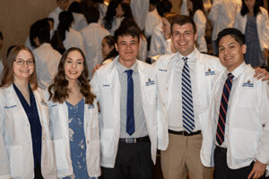 Medical students smile at the camera.