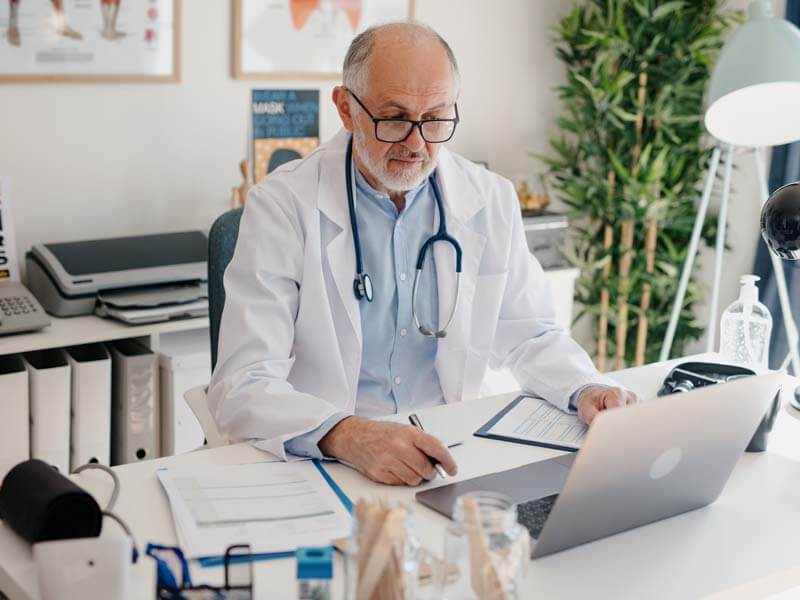 Senior doctor working on his computer