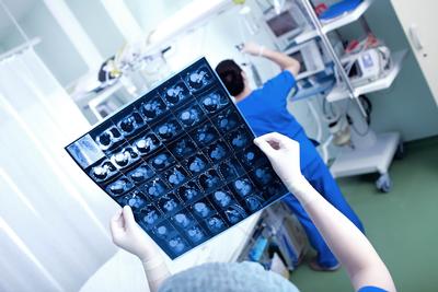 Doctor holding up a print out of a scan results.