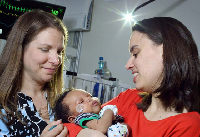 nurse with a mother and baby in NICU