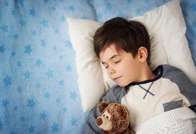 child sleeping peacefully with teddy bear