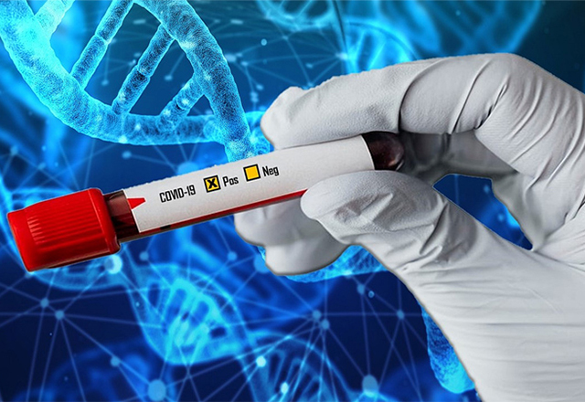 A gloved hand holds a vial containing a coronavirus test.