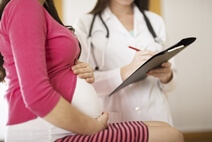 A doctor discusses care with patient laying in hospital bed