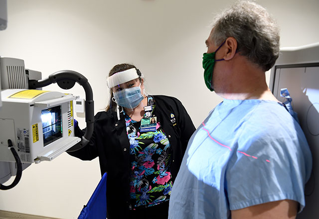 Hospital staff wearing a mask while at a desk.